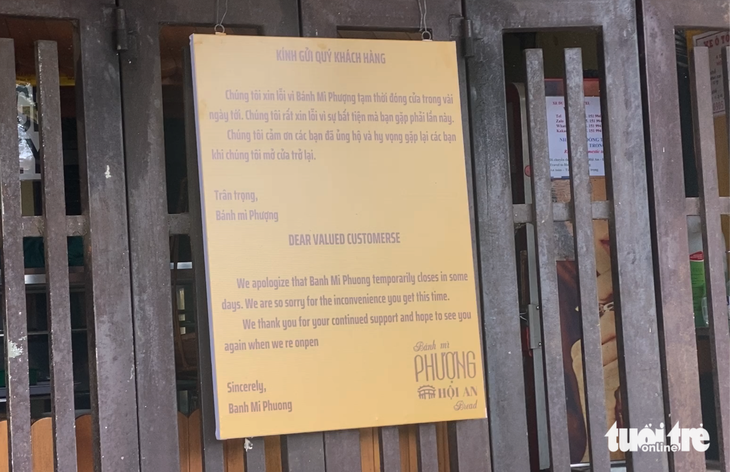 Hàng rong Hội An ngày thu 3 triệu đồng nay chỉ còn một nửa sau vụ ngộ độc bánh mì Phượng - Ảnh 5. Tấm bảng ghi lời xin lỗi và tái ngộ trước tiệm bánh mì Phượng - Ảnh: B.D.