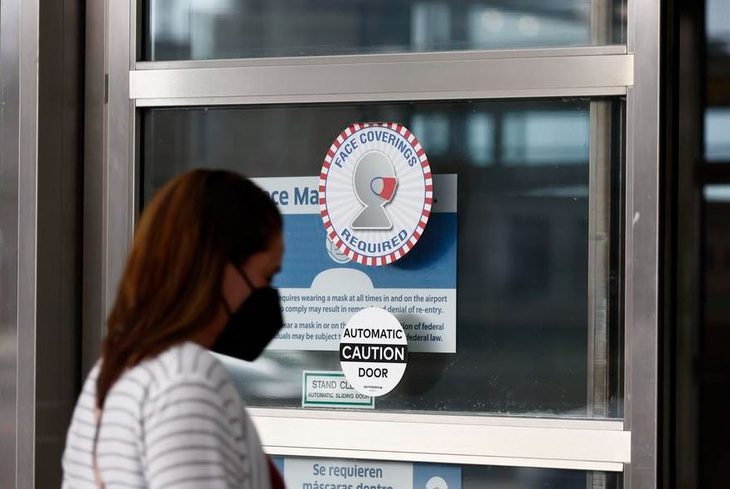 A traveler walks into an entrance at Ronald Reagan Washington National Airport in Arlington, Virginia, the United States, April 14, 2022. (Photo by Ting Shen/Xinhua) 4 năm sau khi bùng phát, COVID-19 vẫn khiến cộng đồng y tế lo lắng - Ảnh: Xinhua