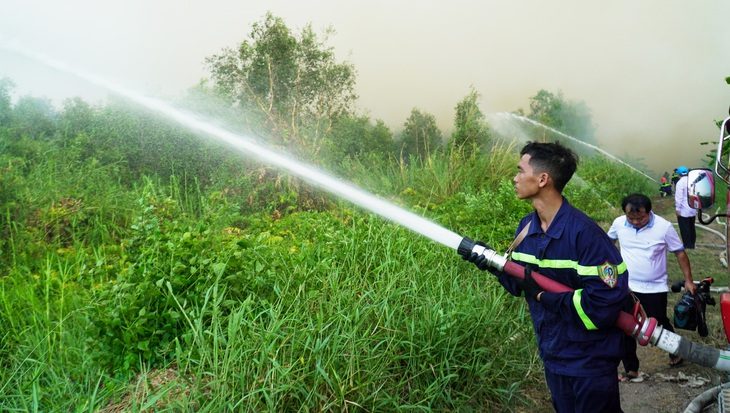 40ha rừng sản xuất ở Cà Mau đang cháy lớn- Ảnh 1. Lực lượng chức năng nỗ lực cắt đường băng để cản lửa - Ảnh: THANH HUYỀN